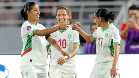 Ghizlane Chebbak (left) celebrates with her Morocco team-mates by going to do a fist bump with one of them