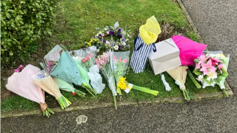 Guy Campbell/BBC Floral tributes left for Joy Middleditch outside her home in Pakefield, Suffolk