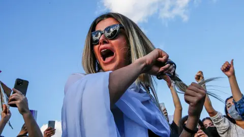  Dilara Senkaya/Reuters A woman cuts her hair in protest against Iranian authorities