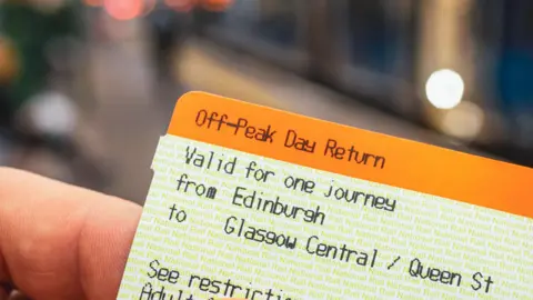 Getty Images A close-up image of a train ticket from Edinburgh to Glasgow Central, held in someone's hand. The ticket is orange and white.