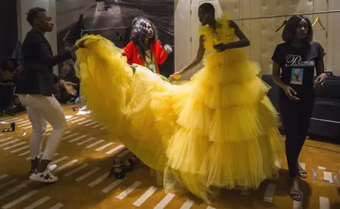 Marta Moreiras Fashion designers, stylists and assistants help a model with her dress backstage at Dakar Fashion Week in Dakar, Senegal