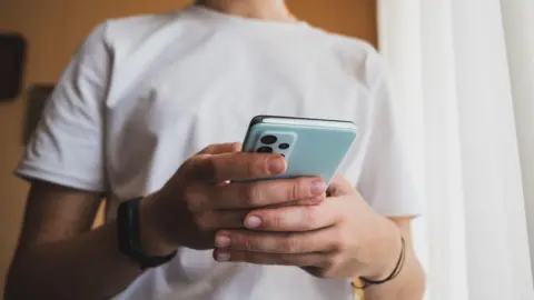 A close-up of hands using a blue smartphone