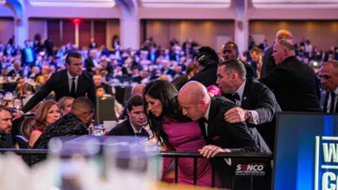 Getty Images Kate Miller and Stephen Miller, one of Trump's most senior aides, are seen being escorted out of the venue.