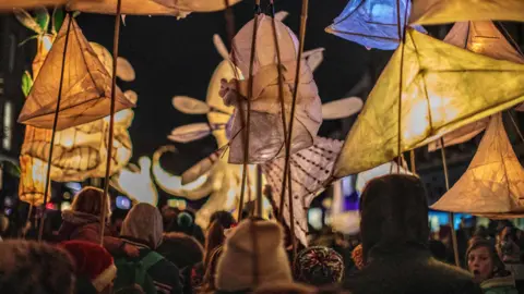Geoff Russell-Hayward MBE at RHImageArt Crowds of people carrying lanterns in the street.