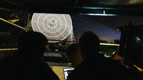 Bluedot A projection team test the light show on the Lovell radio telescope