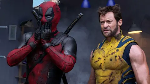 Alamy An image of Deadpool and Wolverine. Deadpool, in his iconic red and black outfit, has his hands over his face in a shocked expression. Wolverine is on his right, looking puzzled.