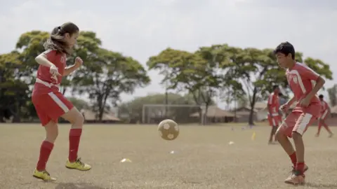 Claudia Jardim Laura Pigatin playing football with her team members