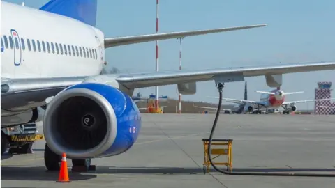 The wing and engine of a plane on the tarmac