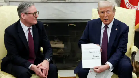 Keir Starmer watches on as Donald Trump displays a letter from King Charles