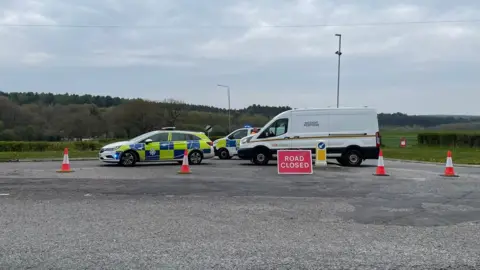 BBC Police vehicles and road closure on Coxmoor Road