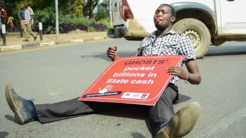 Getty Images Man sitting on the floor with a placard (archive shot from 2018)