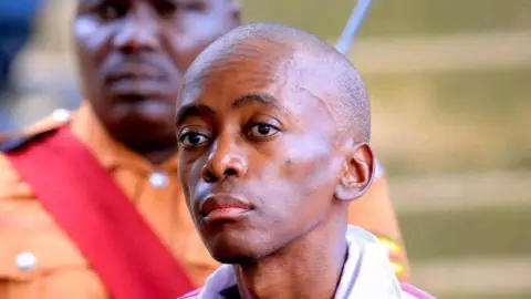 Christopher Okello Onyum stares into the distance, his face is expressionless.