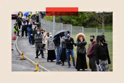 Getty Images Members of the public queue to receive a Covid-19 vaccine 