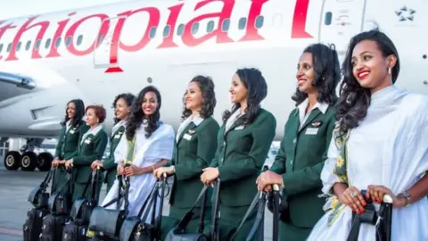 Ethiopian Airlines Female cabin crew on tarmac next to plane