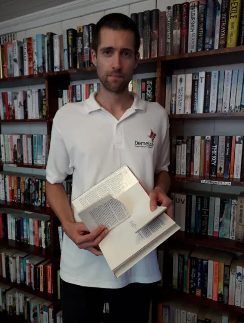 Nick Rogers Bookshop manager Nick Rogers with one of the torn books