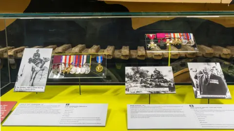 The Tank Museum Display cabinet at museum with medals, photographs and typed information.