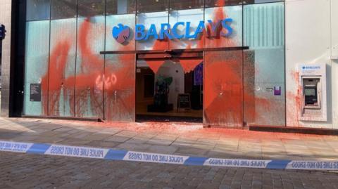 Red paint thrown over a branch of Barclays in Manchester city centre