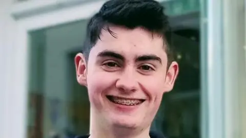 Senan Sheridan Boy with black hair smiling 