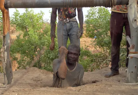 A miner being lowered into a mine at Barkin Ladi