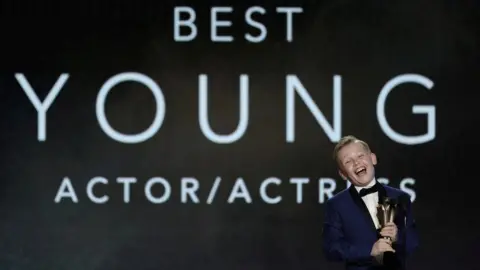 MARIO ANZUONI/REUTERS Jude Hill accepts the award for Young Actor at the Critics Choice Awards