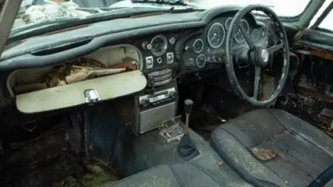 Marc Bow/Timbuktu Content Interior of the car as it was with dirty seats and lots of debris and papers in the glove box