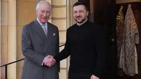 Reuters King Charles shakes hands with Zelensky on the steps outside an entrance to Sandringham palace.