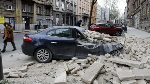 EPA A person walks past rubbles lying on a street after a 5.3-magnitude earthquake that hit near Zagreb, Croatia, 22 March 2020