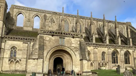 Front view of the abbey from the outside underneath a blue sky