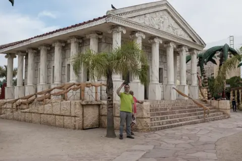 Erica Canepa A man takes a selfie outside a Roman style building