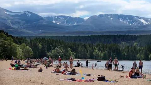 Jane Barlow/PA Wire People on the beach in the Cairngorms