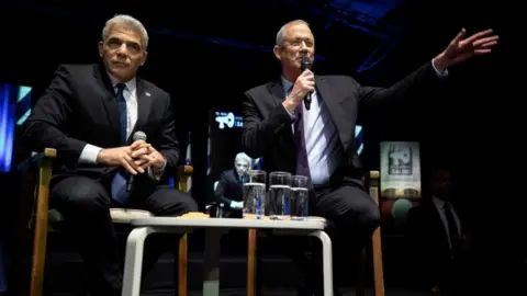 Reuters Yair Lapid (L) and Benny Gantz (R) speak to supporters during a Blue and White rally in Tel Aviv on 17 February 2020