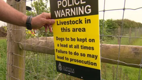 Martin Giles/BBC Police sign warning dog walkers to keep animals on leads