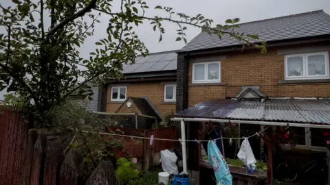 two homes on penderi estate, one with solar the other without