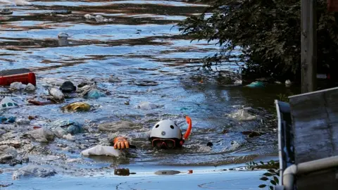 Reuters A rescue worker swims as he checks around a flooded residential area due to Typhoon Hagibis, in Kawasaki, Japan, October 13, 2019