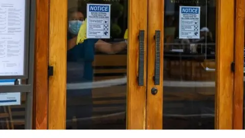 AFP/Getty Images A worker cleans inside a restaurant in Glendale, California. Photo: June 2020