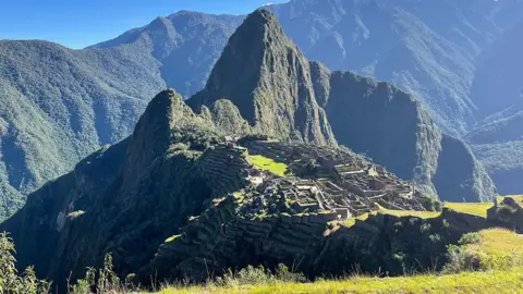 Getty Images The ancient city of Machu Piccu is pictured, surrounded by the green mountains of the Peruvian Andes.