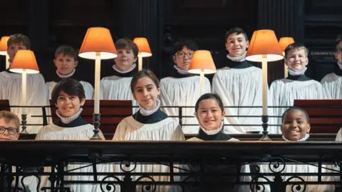 Peter Li/St Paul’s Cathedral Lila and Lois pose next to the boys in the choir inside in their surplice in inside the cathedral