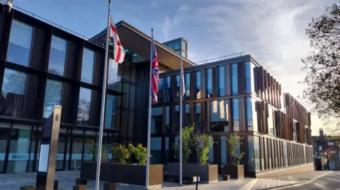 West Northamptonshire Council building. The union jack and St George flag are outside