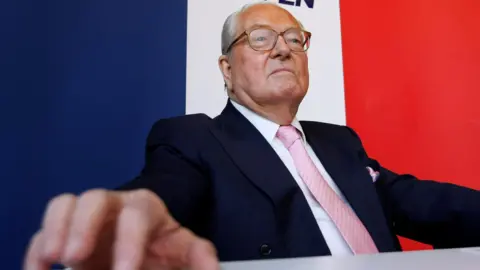 Reuters Jean-Marie Le Pen sat in front of a big tricolour