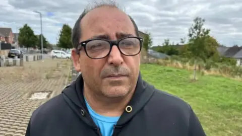 Un hombre con gafas y abrigo negro