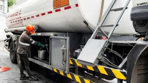 Reuters A worker prepares to fill an underground storage tank at a gas station in the Philippines.