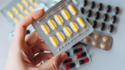 Getty Images Person holding medication packets