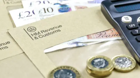 The logo of Her Majesty Revenue and Customs on envelope, with money or check included inside.