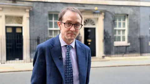 Chris Mason, wearing a blue suit, standing outside 10 Downing Street