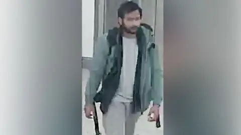 Northamptonshire Police A CCTV picture of the murder suspect Pankaj Lamba wearing a green jacket, a backpack, pale trousers and top. He has a beard and black hair