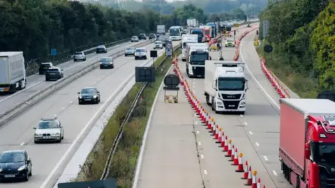 Aerial shot showing lorries being diverted by cones into one lane on M20 for Operation Brock 