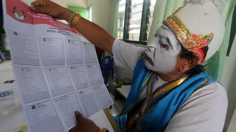 Getty Images Java election official with ballot paper