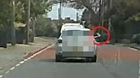 Buckinghamshire Council A blurry image of a car driving along with someone throwing litter out of the driver's side.