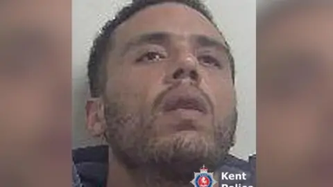 Kent Police A man wearing a dark jacket, tilting his head up. 