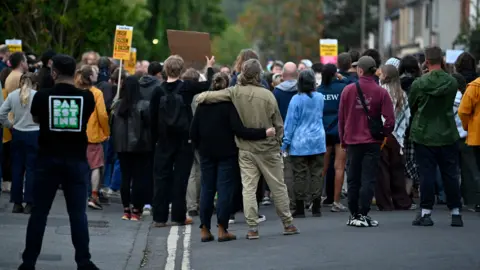 Getty Images A couple embraced in Oxford outside the Asylum Welcome immigration support service office